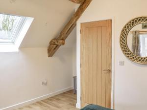 a room with a wooden door and a mirror at The Barn in Llangwm +11 photos