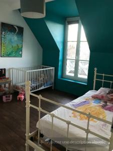 a bedroom with a bed and a blue wall at Villa Alice centre village proche forêt in Barbizon