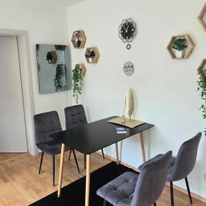 Un comedor con una mesa y sillas negras. en Smartes City Apartment - Top Location!, en Halle an der Saale