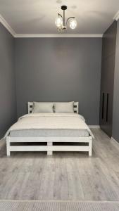 a bedroom with a white bed in a room at Luxury & City Central Apartment & Great Atmosphere in Almaty