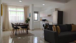 a living room with a couch and a table and a kitchen at Sal Casa VILLAGE in Santa Maria