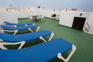 un groupe de chaises bleues dans une pièce avec une table dans l'établissement apartamento anzuelo, à Famara