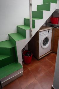 un escalier vert dans une pièce avec une machine à laver dans l'établissement apartamento anzuelo, à Famara