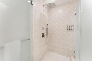 a bathroom with a shower with white tiles at Provident Doral at the Blue Miami in Miami
