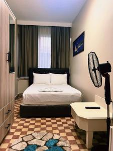 伊斯坦布尔Fındık Palas Otel的一间卧室配有一张床、一张桌子和风扇