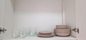 a shelf with glasses and plates and bowls at Sal Casa VILLAGE in Santa Maria +19 photos