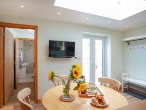 a dining room with a table with sunflowers on it at Trelawney Cottage in Charlestown +19 photos