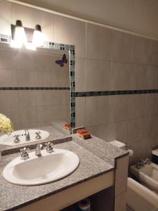 un baño con lavabo y espejo en Casita Alpha, en San Pedro