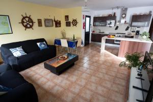 a living room with a couch and a kitchen at apartamento anzuelo in Famara