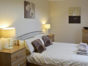 ein Schlafzimmer mit einem Bett mit zwei Lampen in der Unterkunft Abbey Cottage in Longhirst