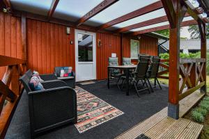 a covered patio with a table and chairs and a table and a table at De Babbel | 4 persons in Gasselte