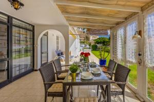 a dining room with a table and chairs on a patio at 3BR Tauro Bungalow - Garden, Terrace, Sleeps 6 in Mogán