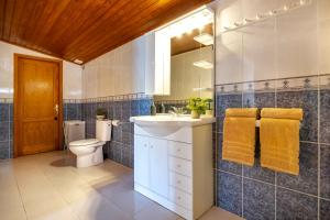 a bathroom with a sink and a toilet and a mirror at 3BR Tauro Bungalow - Garden, Terrace, Sleeps 6 in Mogán