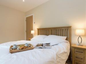 Una cama con una bandeja de comida y un periódico. en Property 2, en Ventnor 8 fotos más