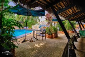 eine Terrasse mit Tisch, Stühlen und Sonnenschirm in der Unterkunft Le Wafou in Abidjan