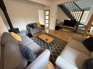 un soggiorno con due divani e una televisione di Fabulous cottage in the heart of the New Forest - Great for families and groups, sleeps 9 a Brockenhurst