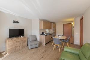 un soggiorno con un divano e una cucina con un tavolo di Cima del ricordo a Pontagna