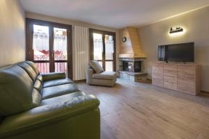 un soggiorno con un divano e una televisione di Cima del ricordo a Pontagna