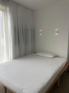 a white bed in a room with a window at Studio in Pettnau