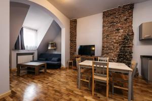 una sala de estar con una mesa y un sofá en YellowBoot Aparthotel, en Sibiu