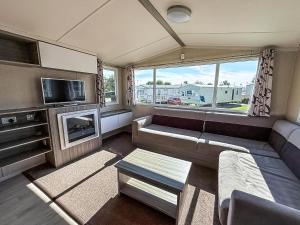 a small living room with a couch and a tv at Stunning 8 Berth Caravan At Cherry Tree Holiday Park In Norfolk Ref 70711C in Great Yarmouth