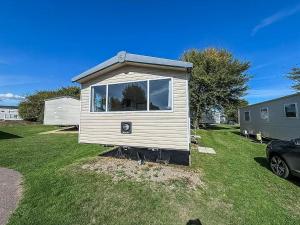 a tiny house with a window in a yard at Stunning 8 Berth Caravan At Cherry Tree Holiday Park In Norfolk Ref 70711C in Great Yarmouth