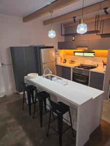 eine Küche mit einer großen weißen Theke und Stühlen in der Unterkunft La Morada del Río - San Ignacio Misiones, Argentina in San Ignacio