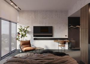 ein Schlafzimmer mit einem Bett, einem Stuhl und einem Fernseher in der Unterkunft West Baltic City in Stettin