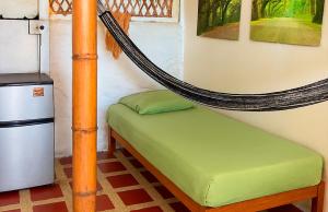 a hammock bed in a room with a refrigerator at Frente al Mar in Dibulla