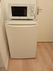a microwave sitting on top of a refrigerator at Maison de village in Ventenac-Cabardès
