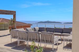 un grupo de sillas sentadas en un patio con vistas al agua en Villa Ghjiseppina Di Pinarello, en Pinarellu