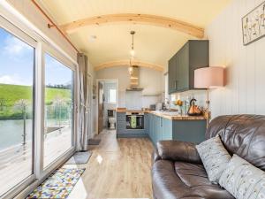 a living room with a couch and a kitchen at Ponsford Ponds - Goosedown Lodge in Cullompton