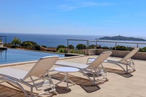 3 sillas y una mesa junto a la piscina en Villa Ghjiseppina Di Pinarello, en Pinarellu 77 fotos más