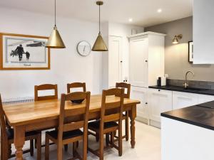 une cuisine et une salle à manger avec une table et des chaises en bois dans l'établissement Weavers Cottage, à Kenmore