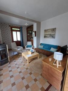 a living room with a blue couch and a fireplace at L'Epicerie Maison années 30 in Caen