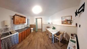 a kitchen with a table and a kitchen with a table and chairs at Tóváros Vendégház in Abádszalók