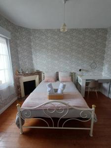 a bedroom with a bed and a table and a fireplace at L'Epicerie Maison années 30 in Caen +5 photos