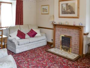 a living room with a couch and a fireplace at Cow Pasture Cottage - Uk2297 in Ebberston