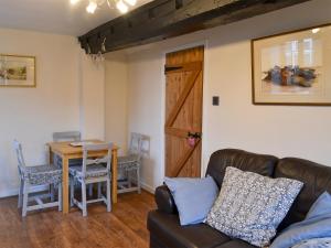 a living room with a couch and a table at Ikkle Cottage in Blidworth
