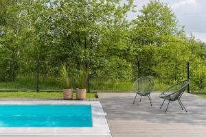 two chairs sitting next to a swimming pool at Polna Osada Nadkole in Nadkole