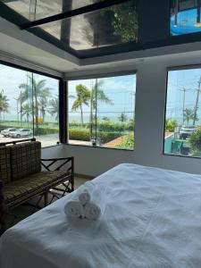 una camera da letto con un letto e vista sull'oceano di Pousada Porto da Barra Praia a Porto Seguro