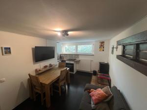 a living room with a table and a television at Cozy Pet Friendly Apartment Freshly Renovated in Maribor