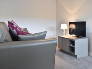 a living room with a couch and a television at Thistle Cottage in Carlton