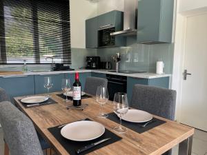 a wooden table with glasses and a bottle of wine at Maison de vacances 6 personnes près de Bordeaux Green Escape in Cenon