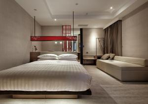 a bedroom with a large bed and a couch at City Place Hotel in Tainan