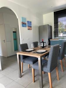 a dining room table with chairs and wine glasses at Maison de vacances 6 personnes près de Bordeaux Green Escape in Cenon