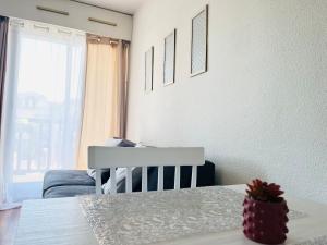 a white dining room with a table and a chair at T2 belle vue mer proche Thalasso - Piscine et tennis in Cabourg +6 photos