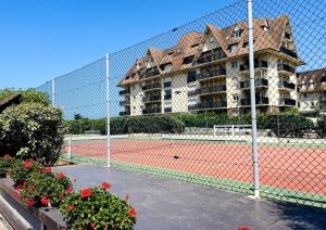 a tennis court in front of a building at T2 belle vue mer proche Thalasso - Piscine et tennis in Cabourg