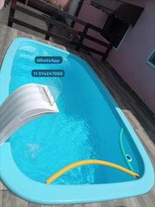 une piscine avec une flèche jaune dans l'eau dans l'établissement Casa Itanhaém, à Itanhaém