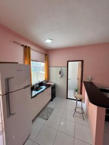 een keuken met een koelkast en een tafel. bij Apartamento no Condomínio il sole in Porto Seguro